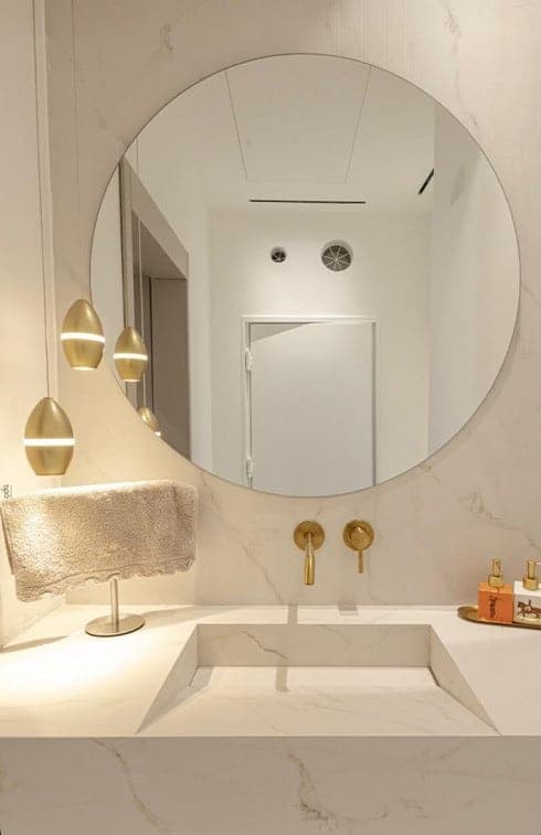 Bathroom vanity and stone wall details with round mirror
